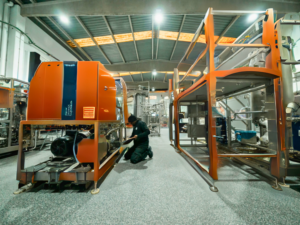 Industrial mechanical engineer inspecting and servicing large machinery as part of equipment maintenance operations.
